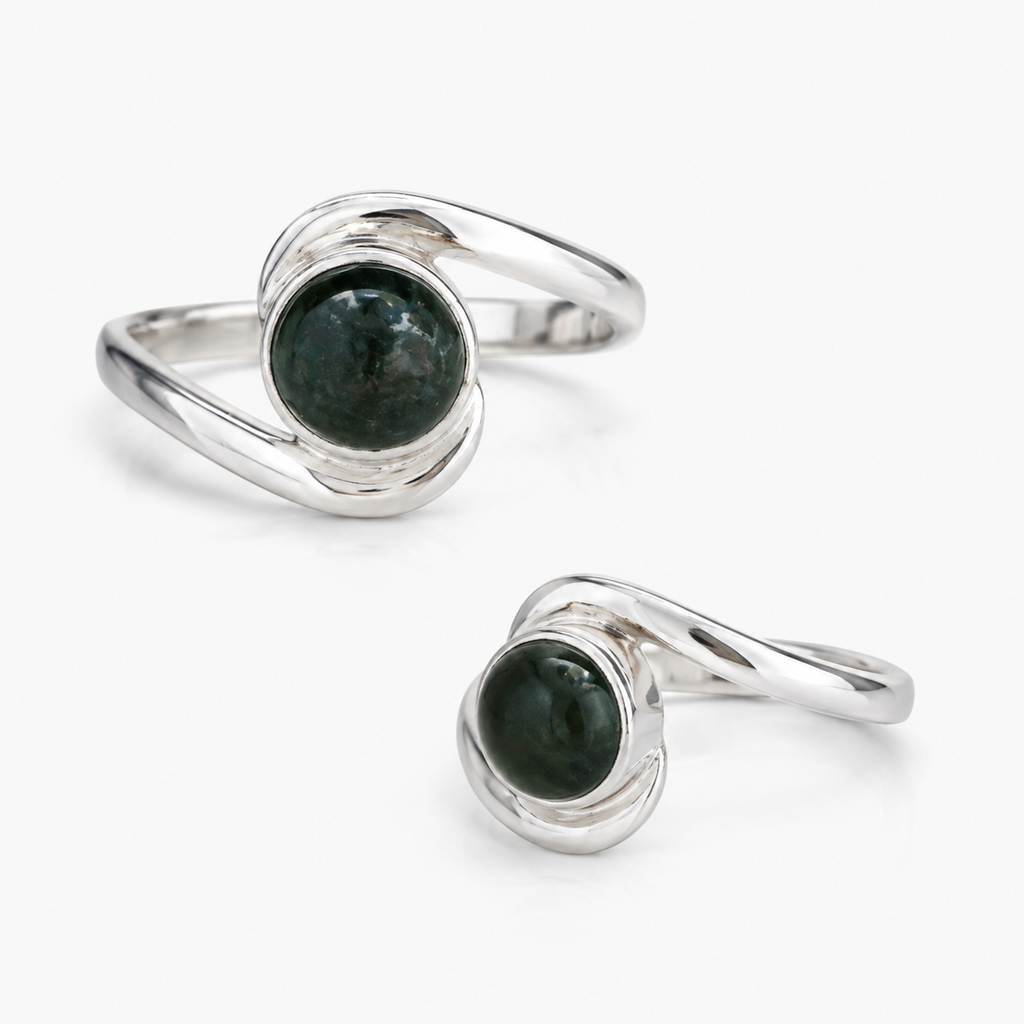 A pair of silver rings with round dark green  jade gemstone centers, displayed on a clean white background.