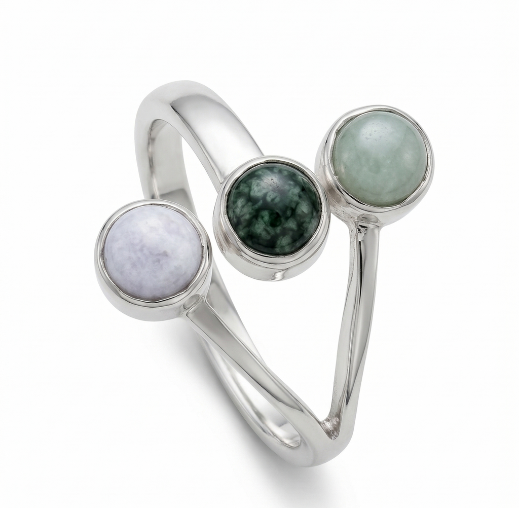 Jade and silver three stone ring against a studio background 