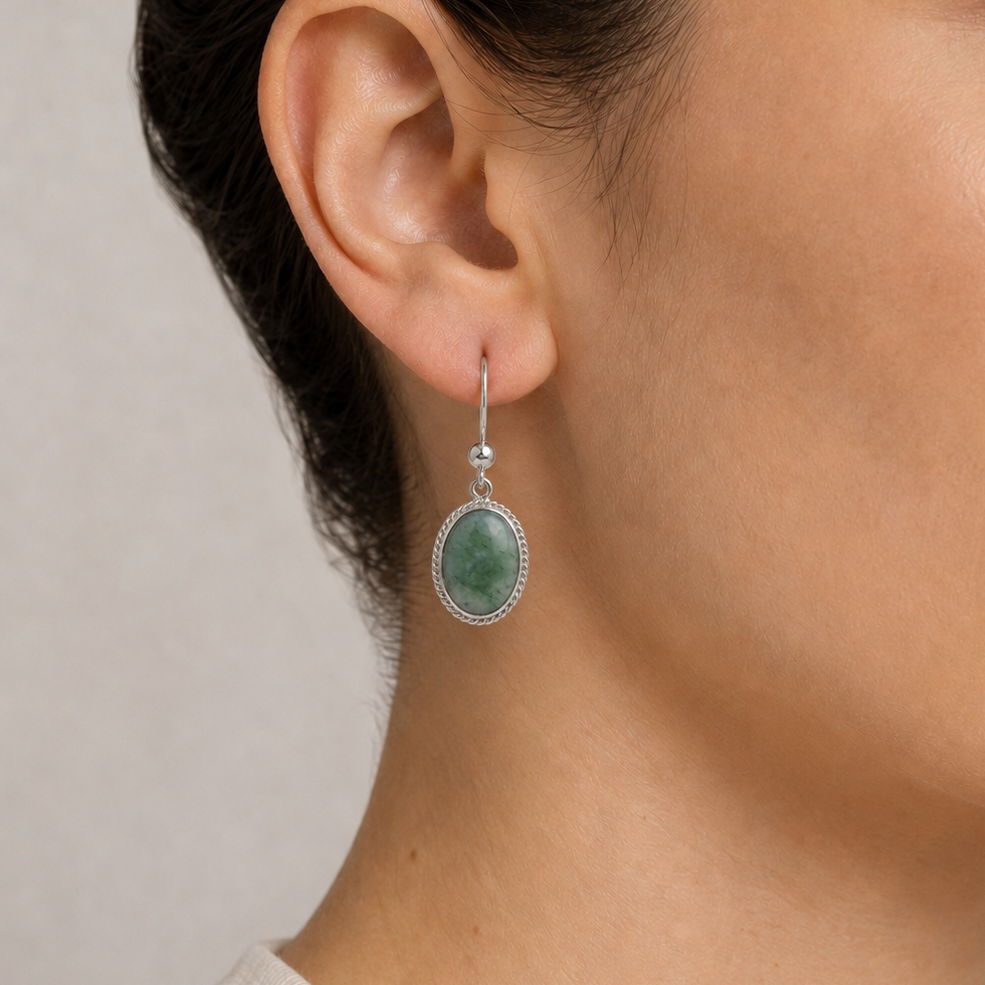 Close-up of a woman wearing princess jade earrings with a neutral background