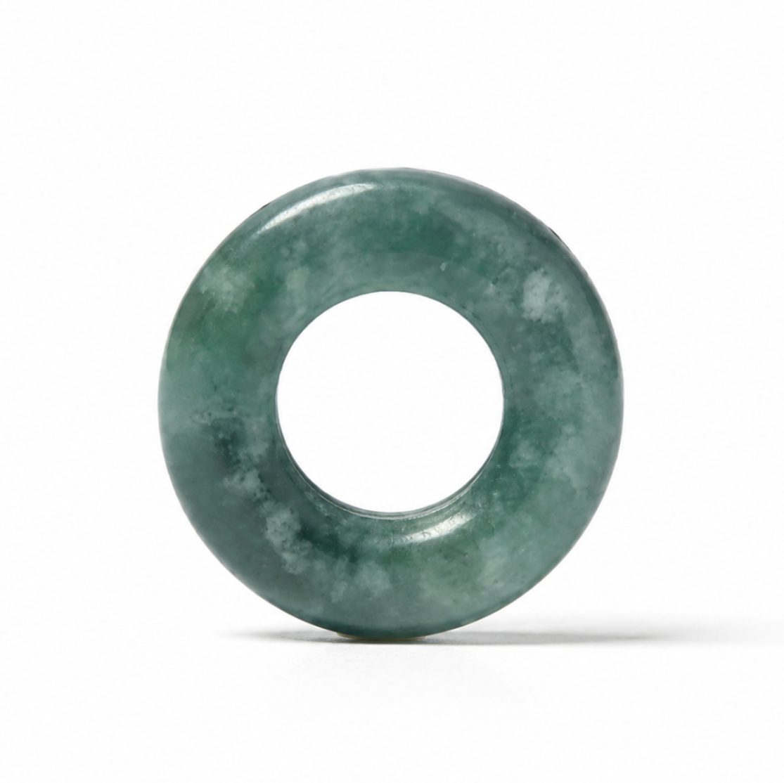 A round green jadeite bangle or ring-shaped pendant with a smooth polished finish, standing upright on a white background with a soft shadow.
