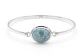 Silver bracelet with a round blue jade stone on a white background